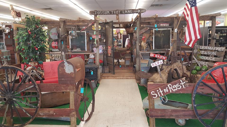 Possum Trot Lane themed aisle inside Ocala Antique Mall and Estates, with vintage wagon wheels, primitives and hand-painted signs